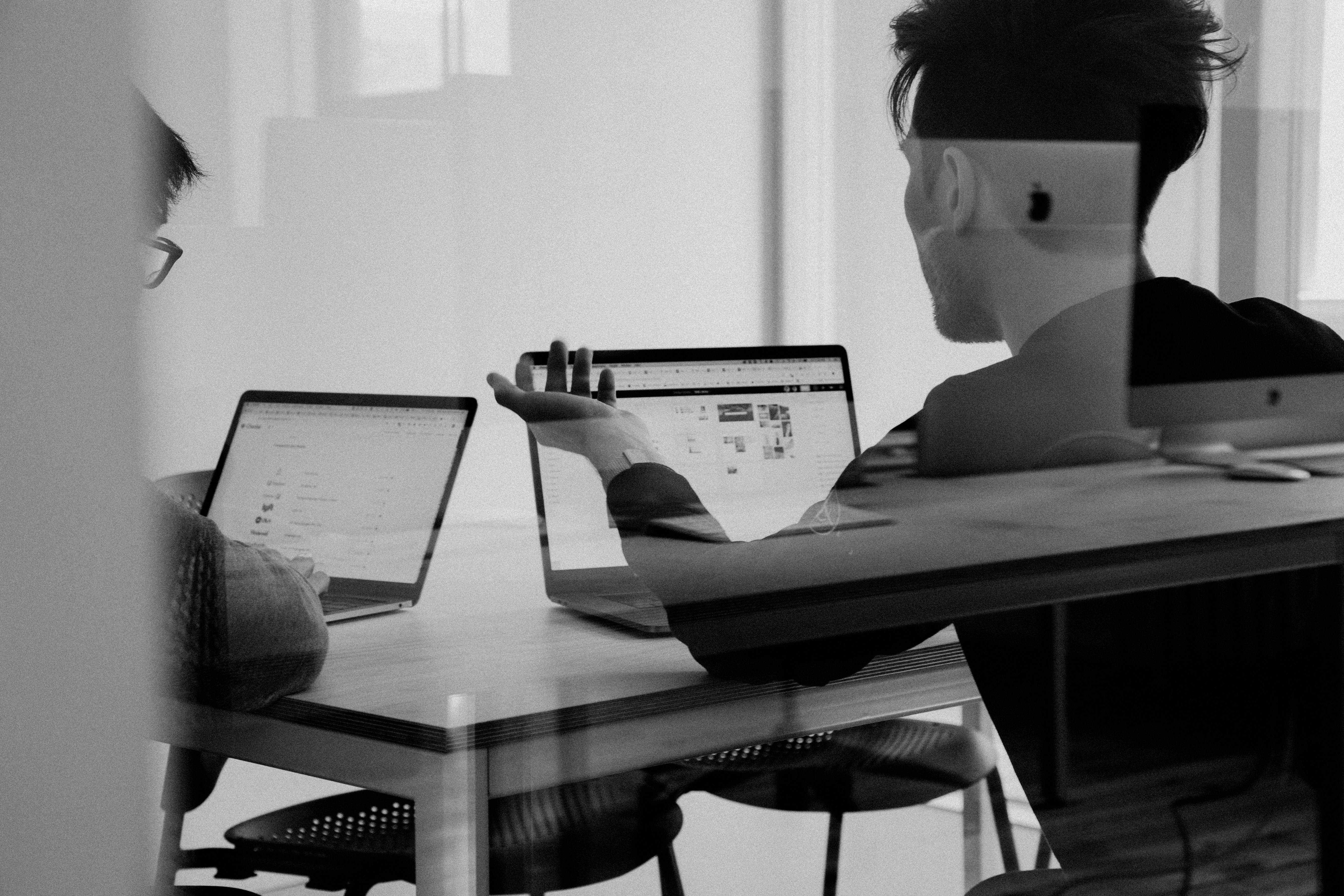 Two people working through a problem at a shared desk